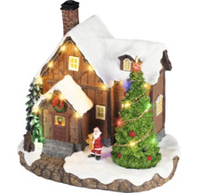 Village de Noël miniature avec une maison enneigée, un sapin illuminé, une figurine de Père Noël et une guirlande lumineuse.