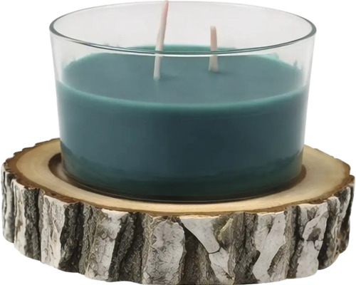 Petrolfarbene Duftkerze im Glas mit zwei Dochten auf einer dekorativen Holzscheibe mit Rinde.