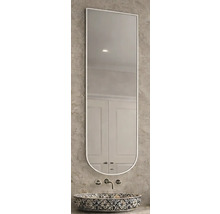 Miroir mural étroit avec bord supérieur droit et bord inférieur arrondi au-dessus d'une vasque à motifs sur un mur texturé.