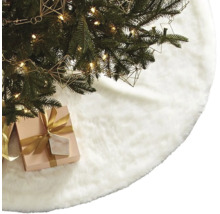 Weihnachtsbaumdecke aus Kunstfell unter einem geschmückten Weihnachtsbaum mit Geschenk.