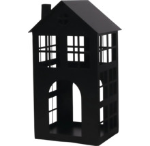 Lanterne en métal noir en forme de maison avec des ouvertures de fenêtres et une cheminée.
