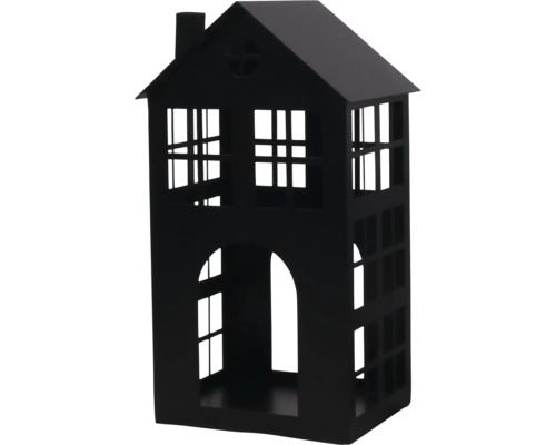 Lanterne en métal noir en forme de maison avec des ouvertures de fenêtres et une cheminée.