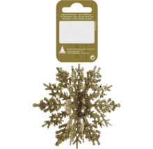 Goldene glitzernde Schneeflocke als Weihnachtsbaumschmuck an einer Kartonaufhängung.