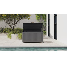 Coffre de rangement de jardin ouvert avec roulettes et poignée sur une terrasse moderne au bord de la piscine avec des plantes.