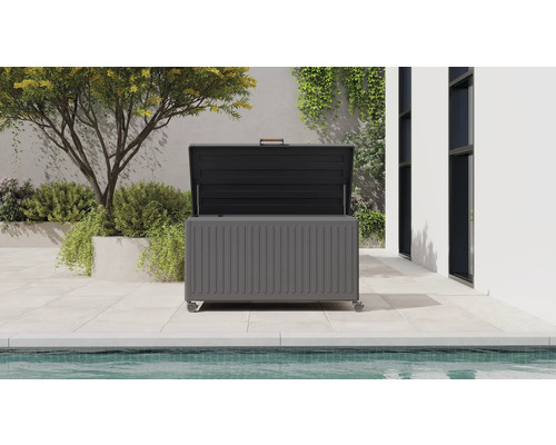 Coffre de rangement de jardin ouvert avec roulettes et poignée sur une terrasse moderne au bord de la piscine avec des plantes.