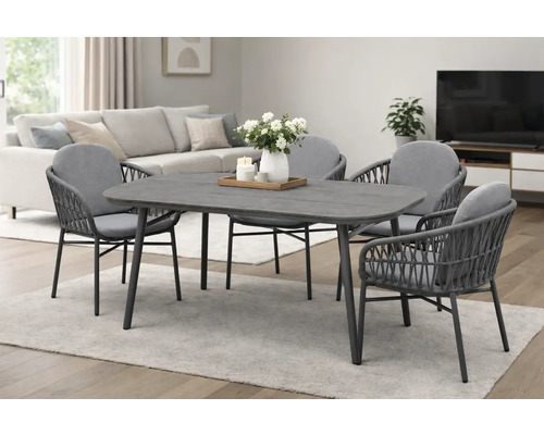 Salle à manger moderne : table rectangulaire grise et quatre chaises en corde tressée avec coussins dans un salon lumineux.