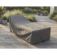 Housse de protection grise pour bain de soleil sur une terrasse en bois dans un jardin lumineux et organisé.