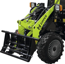 Chargeur compact Zipper avec bras de levage hydraulique, Zipper Logo, phares et pneu à crampons.