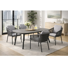 Ensemble de salle à manger moderne avec table ovale gris foncé et quatre chaises de jardin tressées avec coussins gris dans une pièce lumineuse.