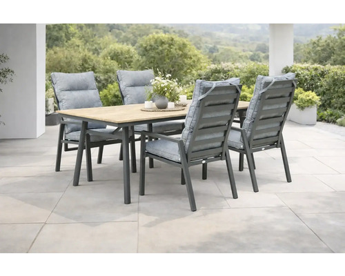 Ensemble de jardin moderne avec une table en bois et métal et quatre chaises dotées de coussins gris sur une terrasse en pierre claire.