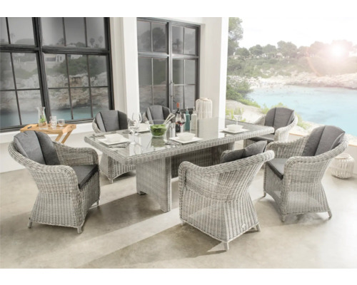 Ensemble de jardin moderne en résine tressée claire avec table en verre et six fauteuils avec coussins gris sur une terrasse organisée et lumineuse.