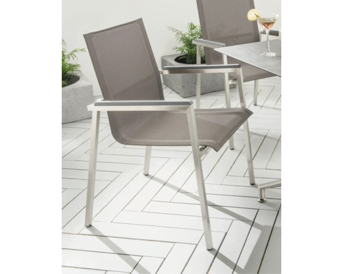 Chaise de jardin moderne avec structure en métal argenté et assise en textile gris sur une terrasse avec motif à chevrons.