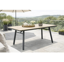 Table de jardin moderne avec plateau aspect bois et cadre en métal foncé sur une terrasse avec plantes et vue sur le paysage.
