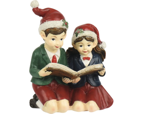 Weihnachtsfigur Junge und Mädchen beim gemeinsamen Lesen in einem Buch, beide tragen Weihnachtsmützen.