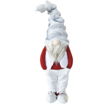 Weihnachts-Wichtel mit grauer Plüschmütze, langem Bart, rotem Strickpullover, weißer Hose und weißen Stiefeln.