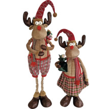 Zwei dekorative Weihnachts-Rentierfiguren aus Plüsch mit karierter Kleidung, spitzen Mützen und Geschenken.