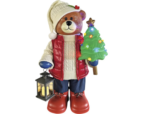 Ours de Noël avec sapin illuminé et lanterne, portant un bonnet en tricot, une veste et des bottes.