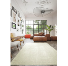 Modernes, helles Wohnzimmer mit hellem Teppich auf Fischgrätparkett, braunem Ledersofa, zwei Sesseln und grosser Fensterfront.