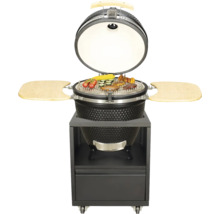 Barbecue Kamado en céramique noir ouvert avec des aliments sur un chariot de barbecue avec deux tablettes latérales en bois et un tiroir.