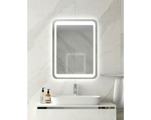 Miroir de salle de bain moderne avec éclairage LED, rectangulaire aux coins arrondis, sur un mur en marbre clair au-dessus d'un lavabo.
