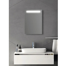 Miroir de salle de bain rectangulaire avec éclairage LED intégré au-dessus d'un lavabo et d'un meuble sous-vasque blancs sur mur gris.