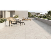 Grosszügige moderne Terrasse mit hellen Terrassenplatten, schwarzen Metallsesseln, Beistelltisch, Holzliegen und bepflanzten Betonkübeln.
