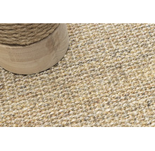 Detailaufnahme eines gewebten Teppichs aus Naturfasern mit einem runden Möbelfuß aus Holz und Seilwicklung.
