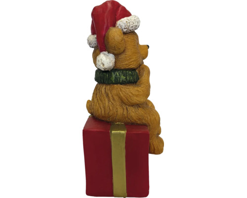 Weihnachtsfigur Bär mit Weihnachtsmütze und Schal, sitzend auf einem roten Geschenkpaket.