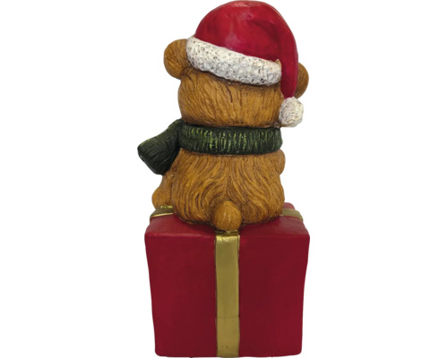 Weihnachtsfigur Teddybär mit Weihnachtsmütze und Schal sitzend auf einem Geschenkpaket, Rückansicht.