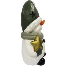 Schneemann-Figur mit grüner Mütze und goldenem Stern, winterliche Weihnachtsdekoration.