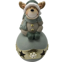 Figurine de renne décorative avec bonnet, écharpe et mitaines sur un socle rond avec étoiles et motif de flocon de neige.