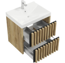 Meuble sous-vasque aspect chêne avec deux tiroirs ouverts à façade en lamelles et lavabo en céramique blanche avec mitigeur.