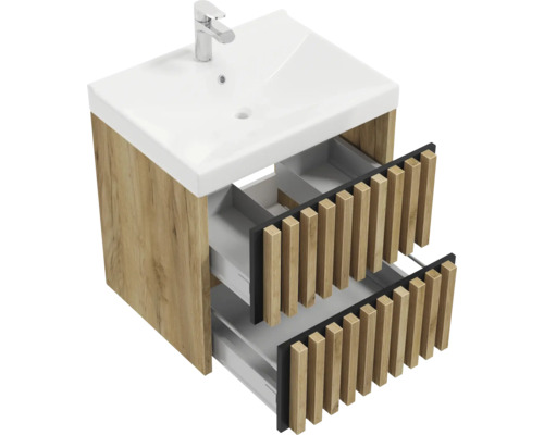 Meuble sous-vasque aspect chêne avec deux tiroirs ouverts à façade en lamelles et lavabo en céramique blanche avec mitigeur.