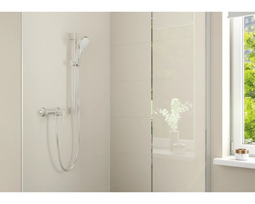Ensemble de douche moderne avec douchette, barre de douche et mitigeur monocommande dans une salle de bains lumineuse.
