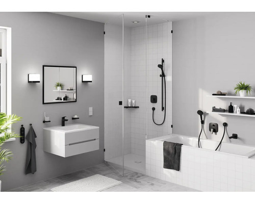 Modernes Badezimmer mit weißem Waschtisch, schwarzer Armatur, Spiegelschrank, begehbarer Glasdusche und Badewanne mit schwarzen Armaturen.