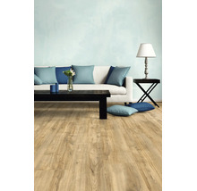 Salon moderne avec revêtement de sol clair aspect bois, canapé blanc avec coussins bleus et table basse noire.