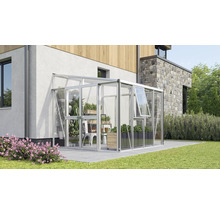 Serre adossée moderne en aluminium et verre, fixée au mur d'une maison sur une terrasse avec des plantes à l'intérieur.