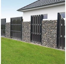 Moderner Gartenzaun aus Gabionen mit grauen Steinen und dunklen vertikalen Sichtschutzelementen auf einer Rasenfläche.