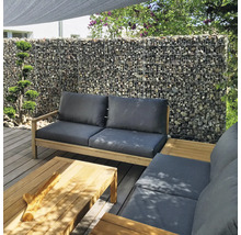 Salon de jardin moderne sur terrasse en bois avec mur de gabions, meubles en bois avec coussins gris et table basse assortie.