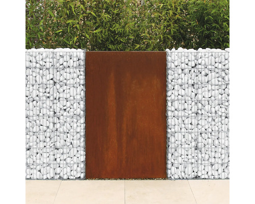 Gabion avec des pierres claires et un élément de brise-vue en acier Corten devant une haie.