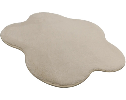 Cremefarbener Kunstfell-Teppich in unregelmässiger Form mit weichem Flor.