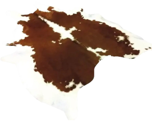 Tapis en peau de vache naturelle avec motif tacheté brun et blanc.