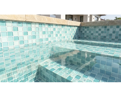 Schwimmbecken mit Mosaikfliesen an Wänden und Treppenstufen, klarem Wasser und Beckenrandsteinen.