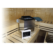 Poêle de sauna en acier inoxydable avec unité de commande numérique dans un sauna en bois avec des bancs sur plusieurs niveaux.