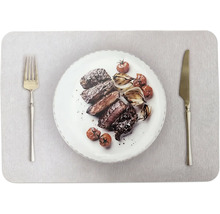 Gegrilltes Fleisch in Scheiben mit gerösteten Zwiebeln und Tomaten auf einem Teller mit Gabel und Messer.