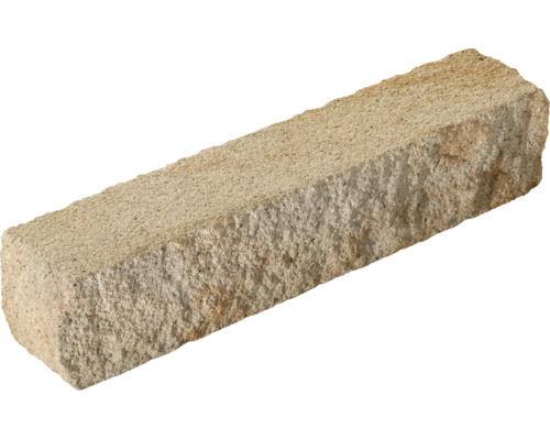 Bloc rectangulaire en pierre naturelle avec une surface rugueuse et texturée.