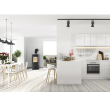 Espace de vie moderne et ouvert avec poêle, cuisine intégrée, salle à manger et terrasse au design clair et minimaliste.