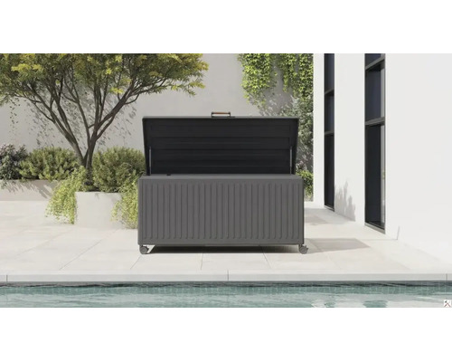 Coffre de jardin ouvert avec roulettes sur une terrasse carrelée au bord d une piscine. Le coffre en métal possède une face rainurée.
