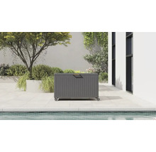 Coffre de jardin moderne en métal avec roulettes et poignée en bois sur une terrasse lumineuse au bord d'une piscine.