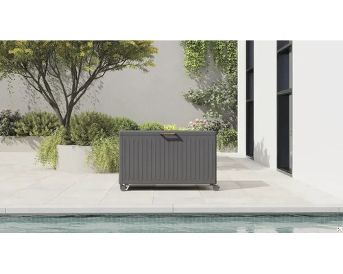 Coffre de jardin moderne en métal avec roulettes et poignée en bois sur une terrasse lumineuse au bord d'une piscine.